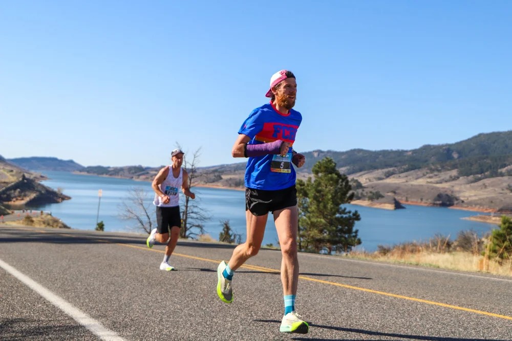 Stephen Pretak running in a road race beside a reservoir